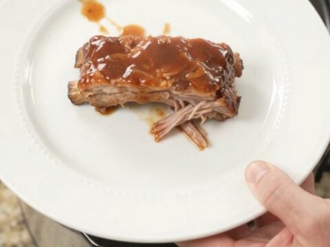 Slow cooker brown sugar BBQ spare ribs glistening with sauce in the Crockpot