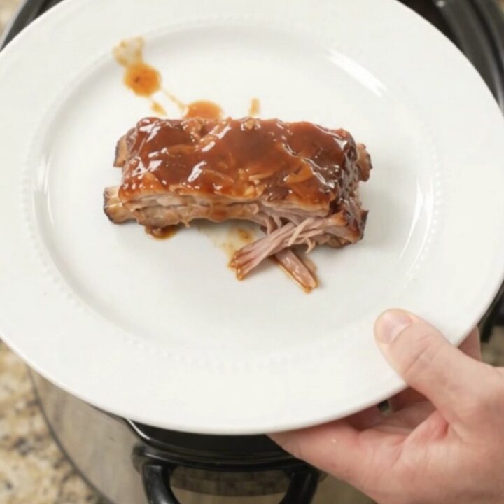 Slow cooker brown sugar BBQ spare ribs glistening with sauce in the Crockpot