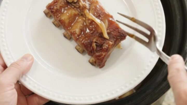 Slow cooker spare ribs glazed with honey hickory barbecue sauce and caramelized onions