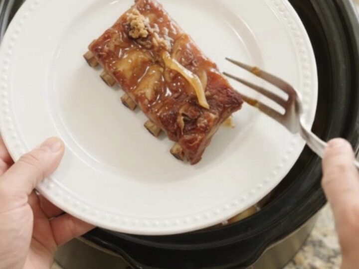 Slow cooker spare ribs glazed with honey hickory barbecue sauce and caramelized onions