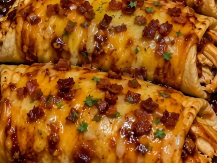 Four golden-brown honey butter BBQ chicken wraps in a glass baking dish with visible melted cheese pull.