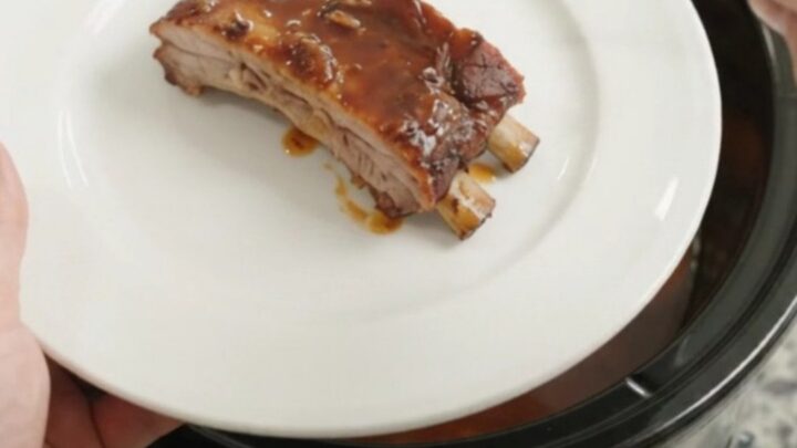 Slow-cooker spare ribs with peaches and BBQ sauce in a black crockpot
