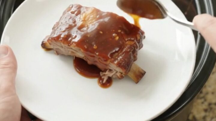 Slow cooker spare ribs coated in sticky chipotle BBQ sauce, glistening and tender in the pot