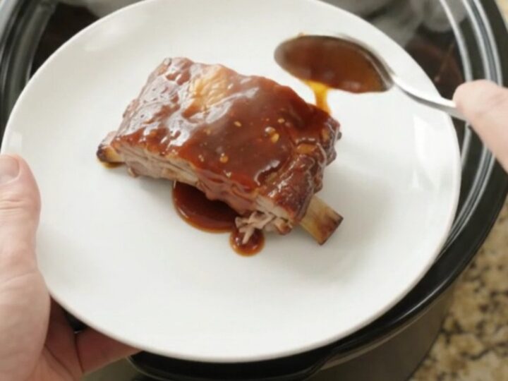Slow cooker spare ribs coated in sticky chipotle BBQ sauce, glistening and tender in the pot