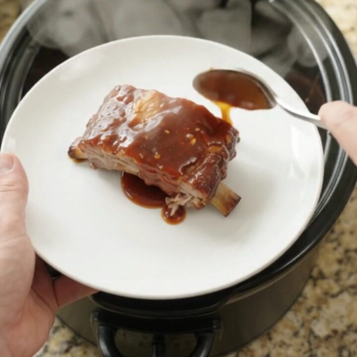Slow cooker spare ribs coated in sticky chipotle BBQ sauce, glistening and tender in the pot
