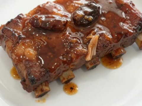 Pull-apart spare ribs glistening with smoky chipotle honey glaze in a black slow cooker