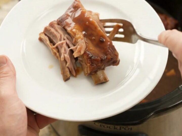 Sticky chipotle molasses spare ribs in a slow cooker with sauce bubbling