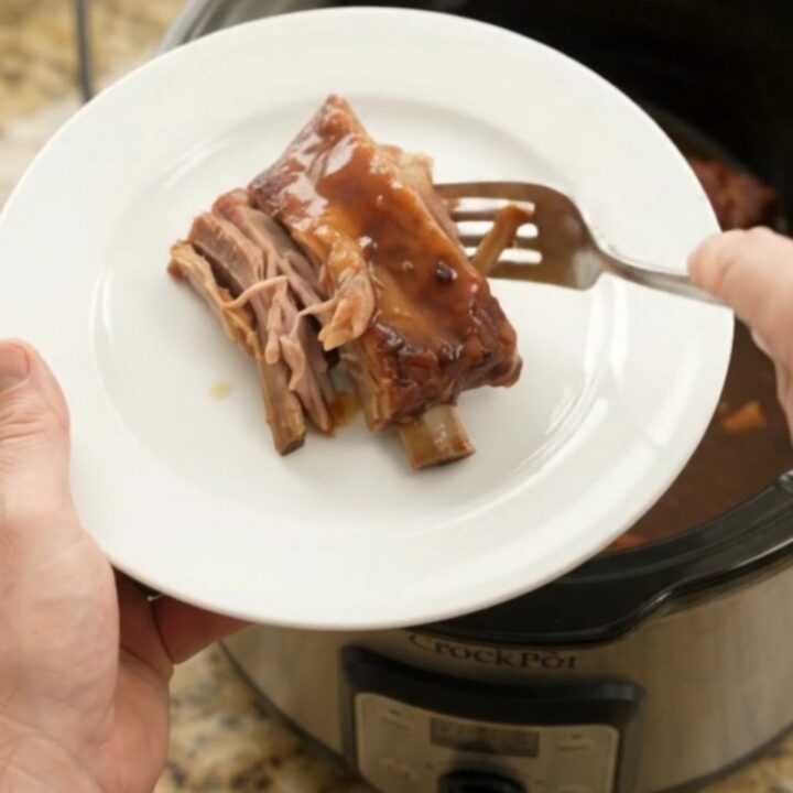 Sticky chipotle molasses spare ribs in a slow cooker with sauce bubbling