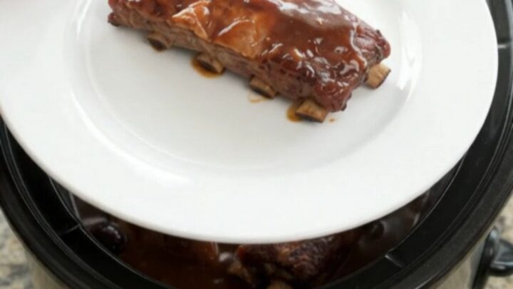 Pull-apart pork spare ribs glazed with cherry cola BBQ sauce in a slow cooker.
