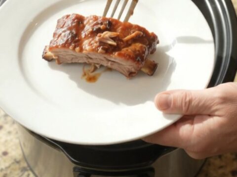 Slow cooker spare ribs coated in glossy BBQ sauce with paprika rub