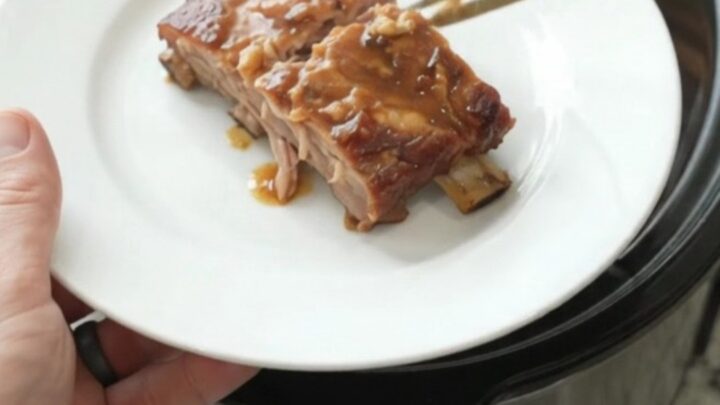 Slow cooker maple bourbon spare ribs glazed with sauce, garlic and rosemary
