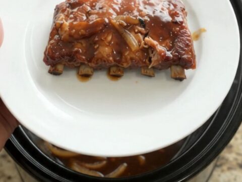 Pull-apart spare ribs glazed with molasses garlic sauce and topped with caramelized Vidalia onions in a slow cooker.