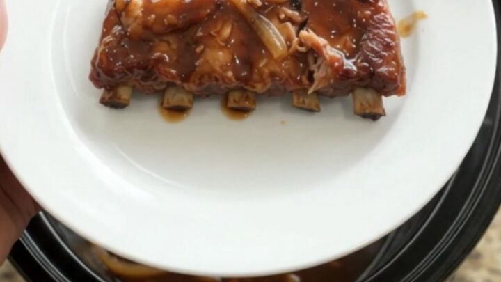 Pull-apart spare ribs glazed with molasses garlic sauce and topped with caramelized Vidalia onions in a slow cooker.