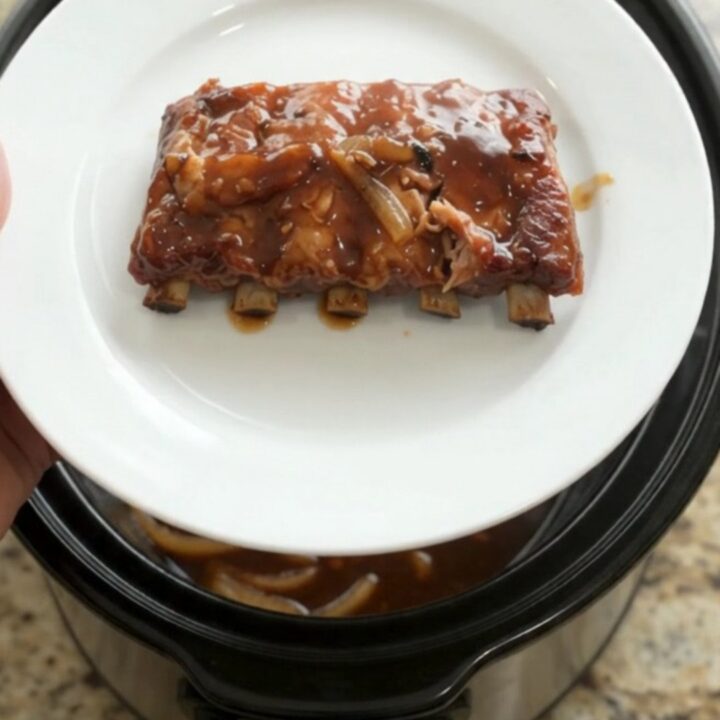 Pull-apart spare ribs glazed with molasses garlic sauce and topped with caramelized Vidalia onions in a slow cooker.