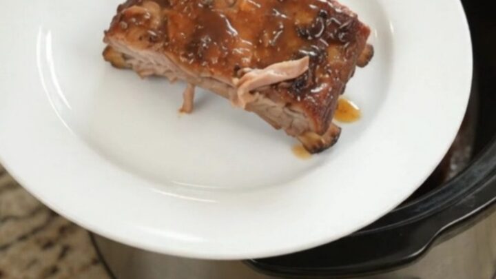 Slow-cooker spare ribs glazed with honey hickory barbecue sauce, garnished with fresh herbs