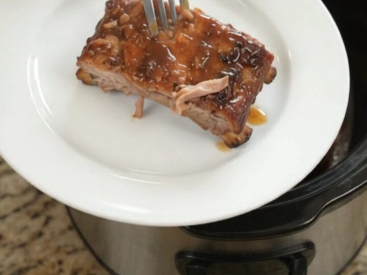 Slow-cooker spare ribs glazed with honey hickory barbecue sauce, garnished with fresh herbs