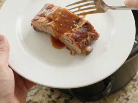 Tender slow-cooker spare ribs glazed with maple bourbon barbecue sauce in the crockpot