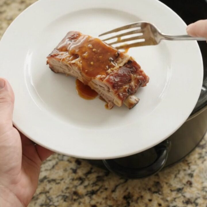 Tender slow-cooker spare ribs glazed with maple bourbon barbecue sauce in the crockpot