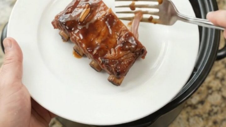Slow-cooker spare ribs coated in glossy molasses garlic sauce with rosemary sprigs