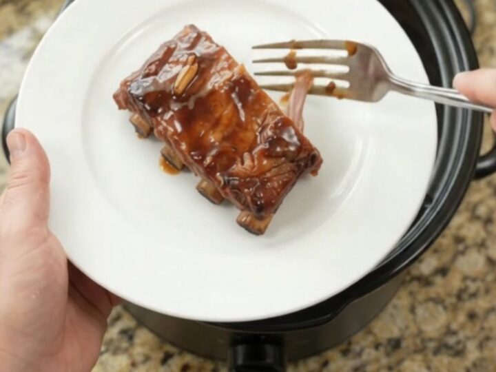 Slow-cooker spare ribs coated in glossy molasses garlic sauce with rosemary sprigs