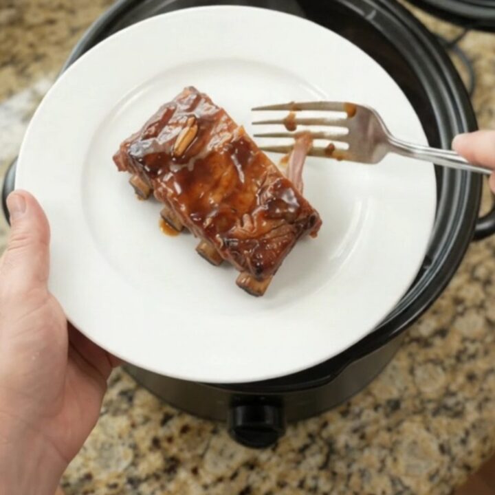 Slow-cooker spare ribs coated in glossy molasses garlic sauce with rosemary sprigs