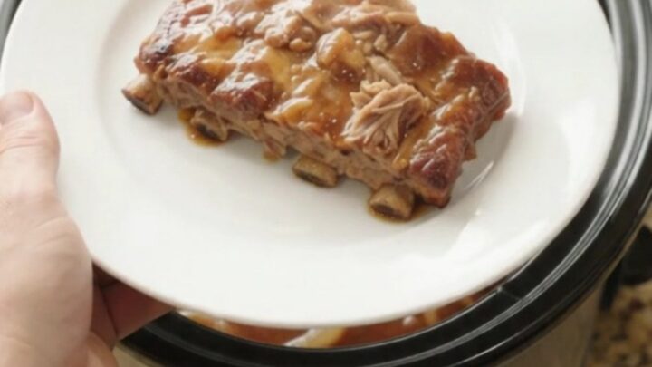 Slow cooker spare ribs glazed with honey hickory sauce and topped with caramelized onions.