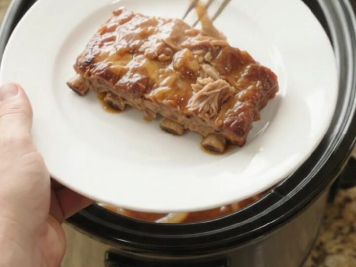 Slow cooker spare ribs glazed with honey hickory sauce and topped with caramelized onions.