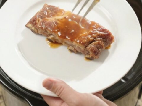 Slow cooker spare ribs glazed in root beer maple bourbon sauce with caramelized onions.