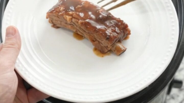 Slow cooker brown sugar molasses country pork ribs with caramelized onions in a dark glossy sauce.