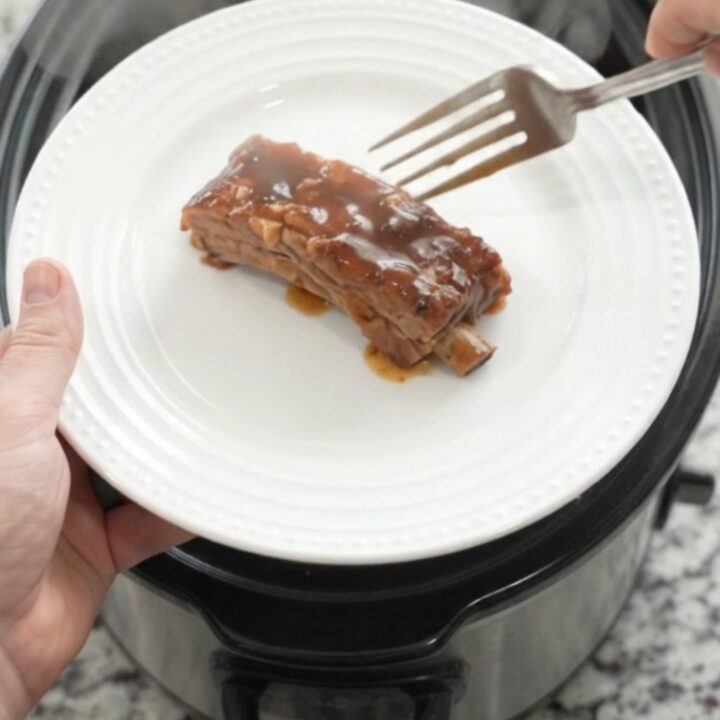 Slow cooker brown sugar molasses country pork ribs with caramelized onions in a dark glossy sauce.