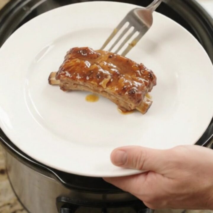 Glazed pork ribs with pineapple rings in a slow cooker, bubbling sauce