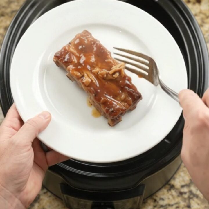 Slow-cooker pineapple maple bourbon country pork ribs with caramelized pineapple rings in glossy sauce.