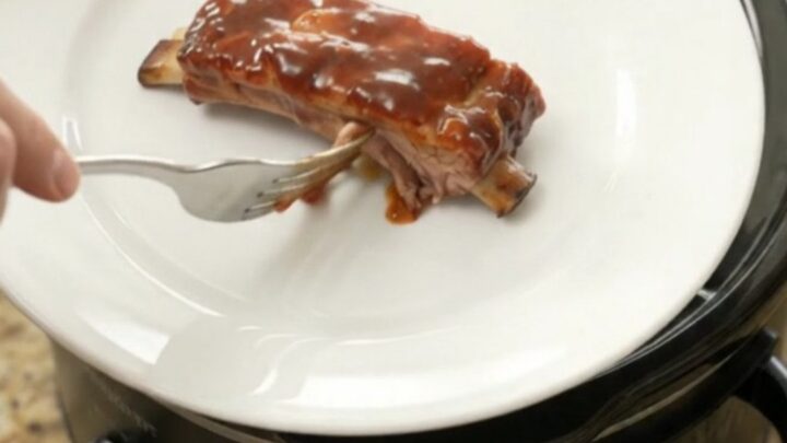 Slow cooker full of glazed pork ribs in chipotle BBQ sauce