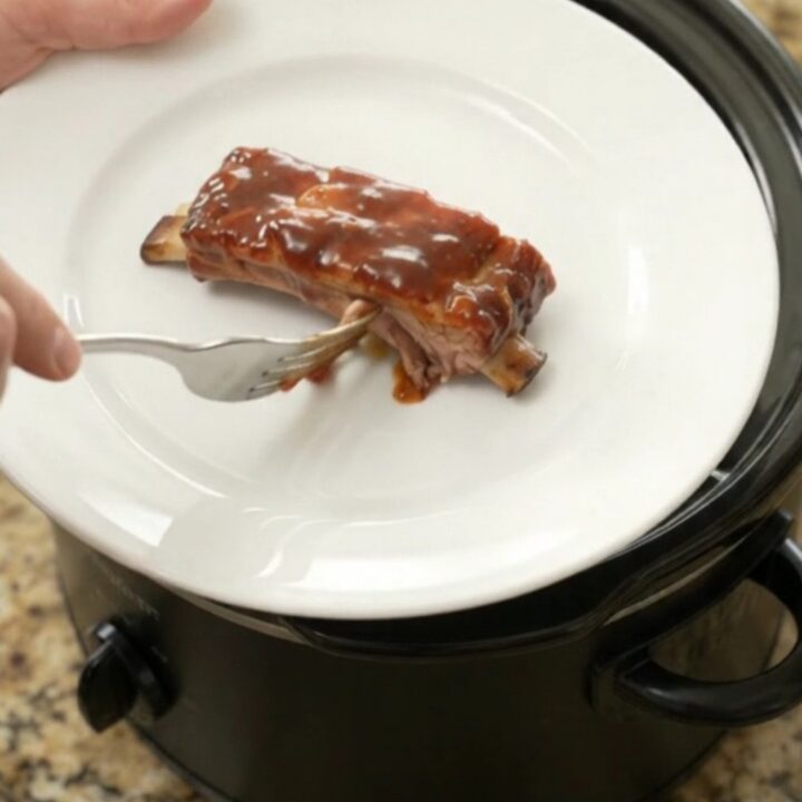 Slow cooker full of glazed pork ribs in chipotle BBQ sauce
