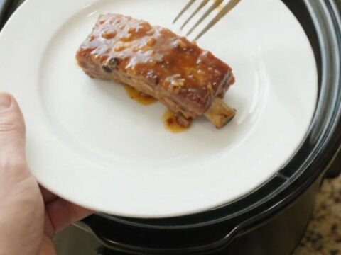 Fork-tender country-style pork ribs glazed with maple bourbon BBQ sauce in a slow cooker