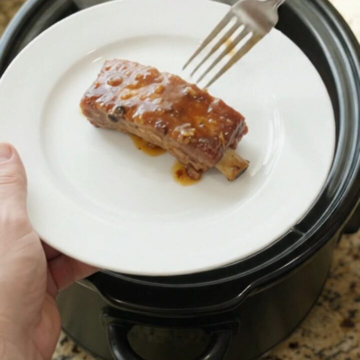 Fork-tender country-style pork ribs glazed with maple bourbon BBQ sauce in a slow cooker