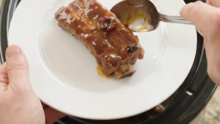 Tender glazed country-style pork ribs in a slow cooker with cherry cola barbecue sauce