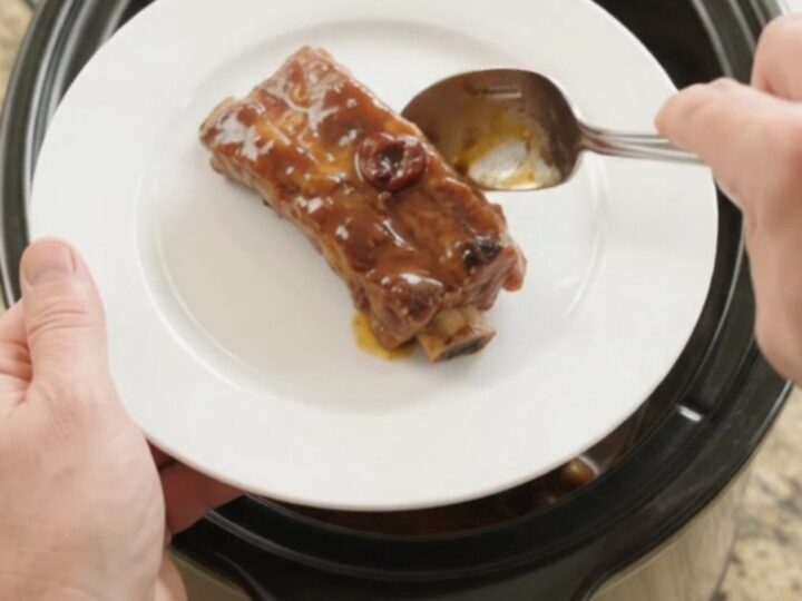 Tender glazed country-style pork ribs in a slow cooker with cherry cola barbecue sauce