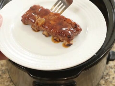 Tender country-style pork ribs glazed with honey hickory barbecue sauce and caramelized onions in a slow cooker.
