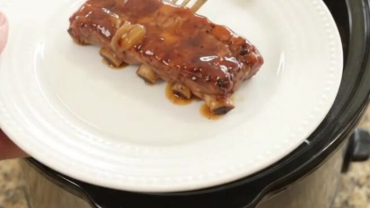Tender country-style pork ribs glazed with honey hickory barbecue sauce and caramelized onions in a slow cooker.