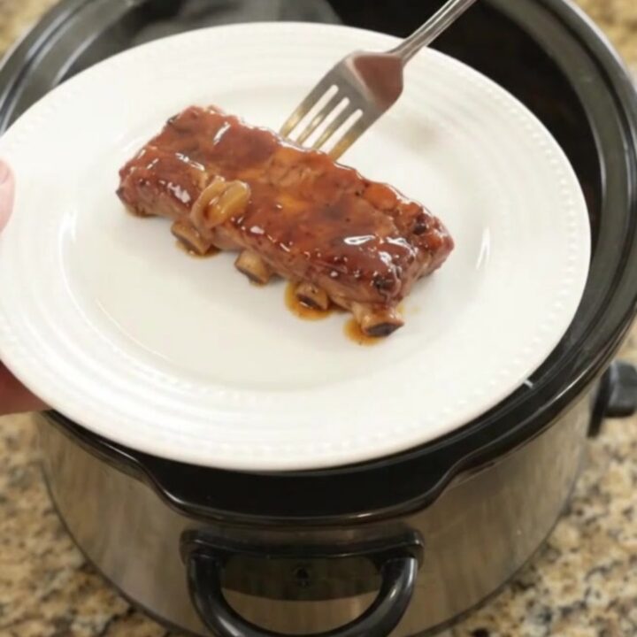 Tender country-style pork ribs glazed with honey hickory barbecue sauce and caramelized onions in a slow cooker.
