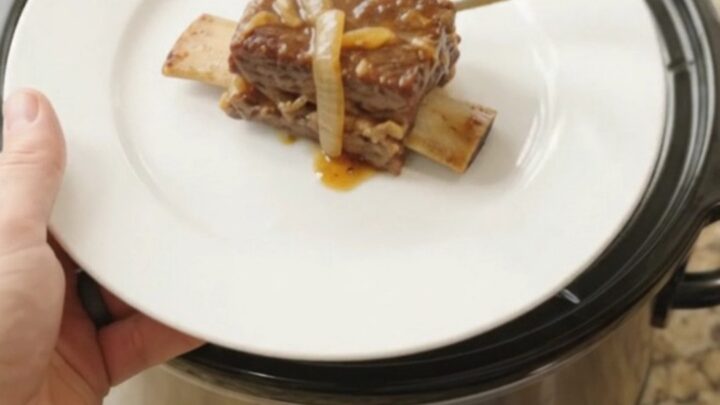 Beef short ribs glazed in maple-bourbon barbecue sauce with caramelized onions in a slow cooker