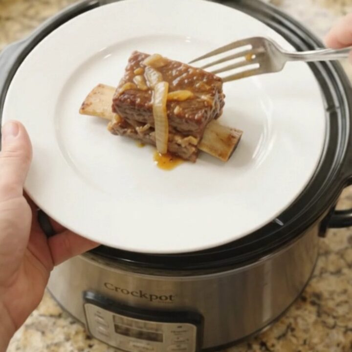 Beef short ribs glazed in maple-bourbon barbecue sauce with caramelized onions in a slow cooker
