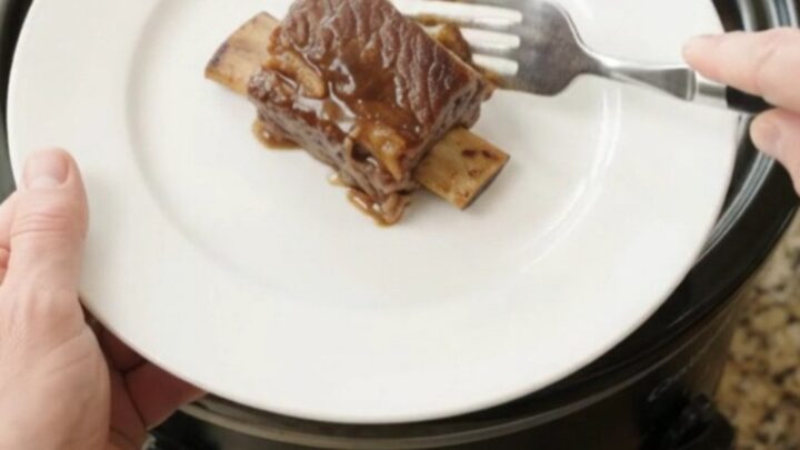 Melt-off-the-bone beef short ribs in a glossy molasses garlic sauce with braised apple slices in a slow cooker
