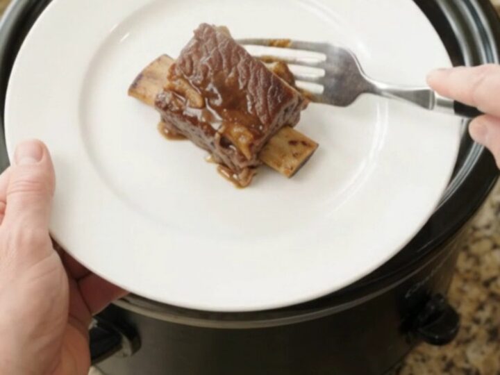Melt-off-the-bone beef short ribs in a glossy molasses garlic sauce with braised apple slices in a slow cooker