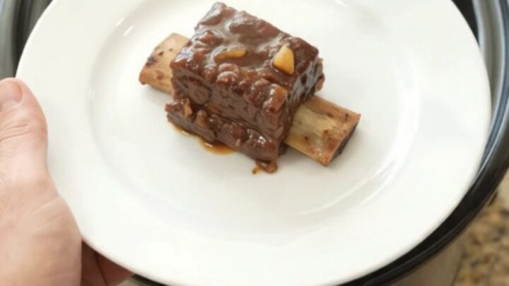 Beef short ribs glazed in a dark molasses chipotle sauce in a slow cooker