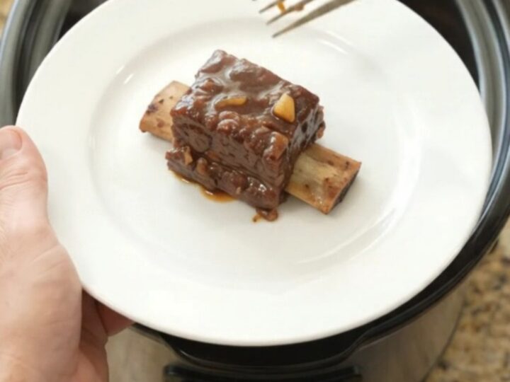 Beef short ribs glazed in a dark molasses chipotle sauce in a slow cooker