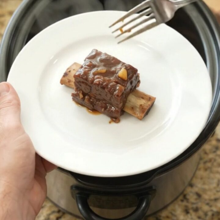 Beef short ribs glazed in a dark molasses chipotle sauce in a slow cooker