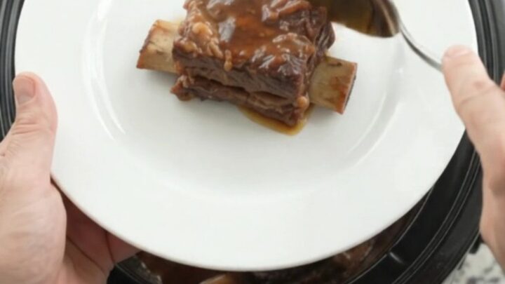 Slow-cooked beef short ribs glazed with smoky chipotle honey barbecue sauce in a black slow cooker