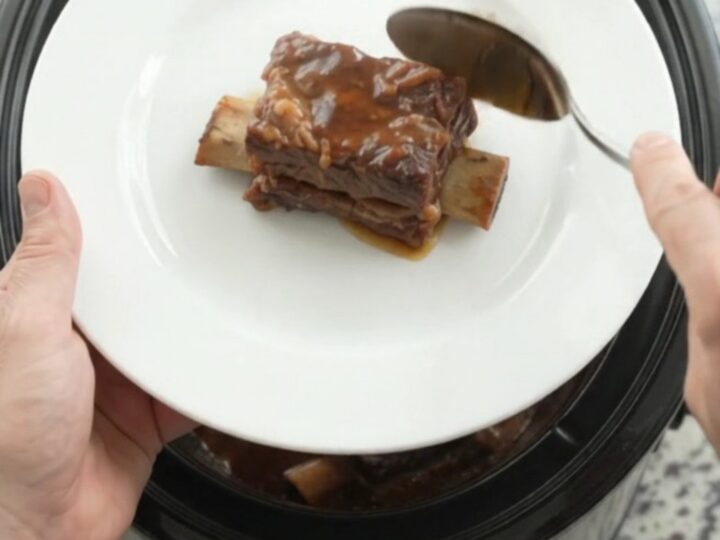 Slow-cooked beef short ribs glazed with smoky chipotle honey barbecue sauce in a black slow cooker